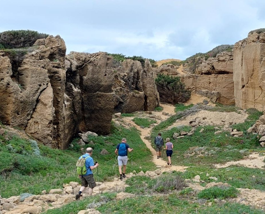 Wandelaars in rotsachtig canyonlandschap met groene begroeiing