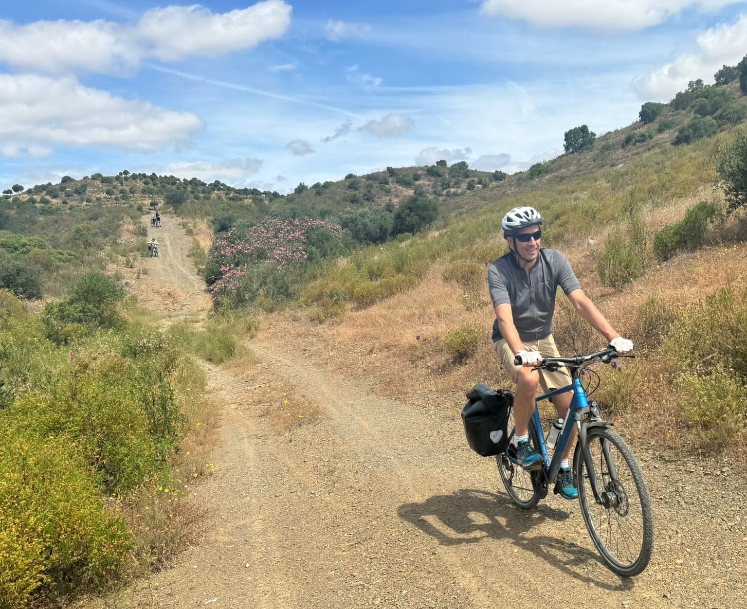 Man fietst over stoffig bergpad in heuvelachtig landschap