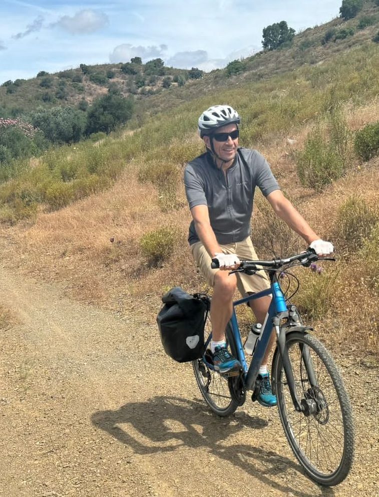 Man fietst over stoffig bergpad in heuvelachtig landschap
