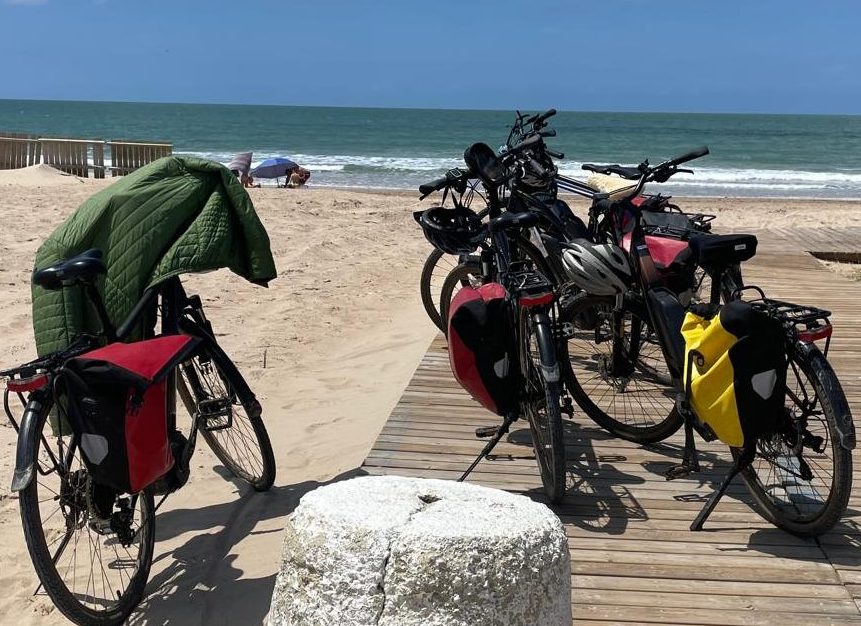 Fietsen met fietstassen op strand bij zee